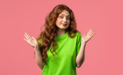 Confused pretty woman, shoulders up - can't help, makes gesture of I dont know.