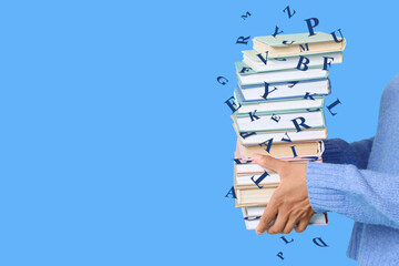 Female hands holding books on blue background