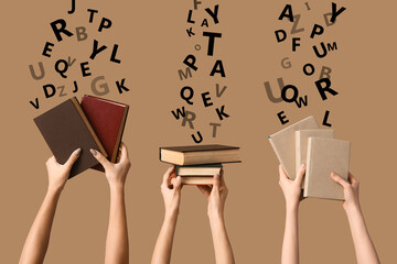 Hands holding many books on beige background