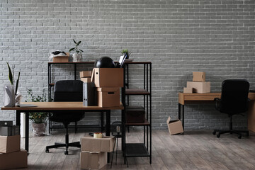 Workplaces with cardboard boxes in office on moving day