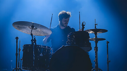 Fototapeta premium Drummer is captured in striking blue light behind a drum kit playing a song Rhythm and beat create art