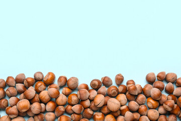 Shelled hazelnuts on blue background, closeup