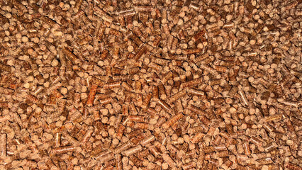 Close-up of brown wood pellets for biomass heating, renewable energy, eco-friendly fuel or sustainable energy resource themes in industrial and home settings