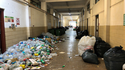Polluted Corridor: An environmental problem captured in a long, cluttered corridor, strewn with plastic bottles and overflowing garbage bags.