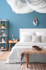 Interior of bedroom with dream catcher and bed