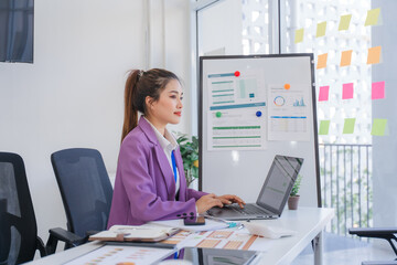 Asian Woman Working on Laptop in Modern Office