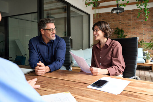 Happy busy business people corporate executive recruitment team talking at group meeting. Female manager working with colleagues in office, consulting client or investor, hr taking job interview.