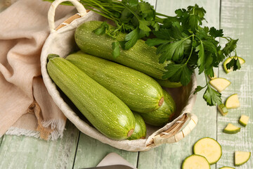 Many fresh zucchini and parsley on green wooden background