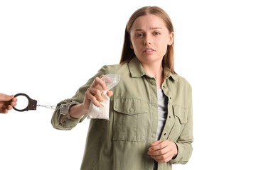 Young female junkie with drugs and handcuffs on white background
