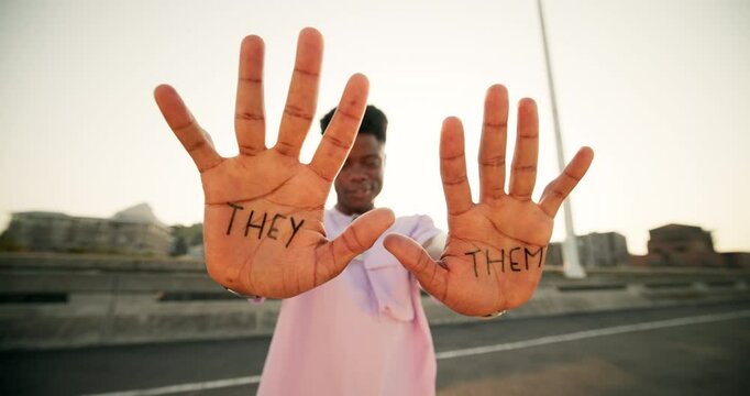 Happy, person and hands with pronouns in city for gender neutral, terminology or awareness. Nonbinary identity, inclusion and face with text on palm at sunset for they, them or preference information