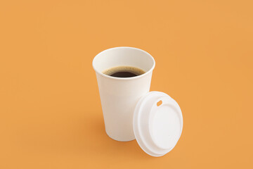 Takeaway paper cup of tasty coffee on beige background