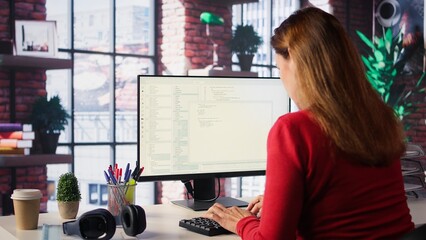 Woman engaging with an intelligent AI chatbot to complete work related tasks, working from loft...