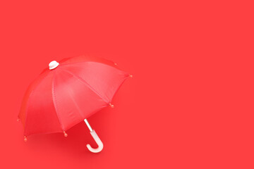Mini stylish umbrella on red background