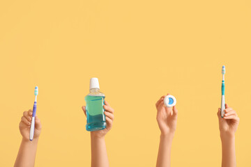 Female hands with oral hygiene supplies on color background