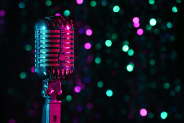 Retro microphone against blurred lights, closeup
