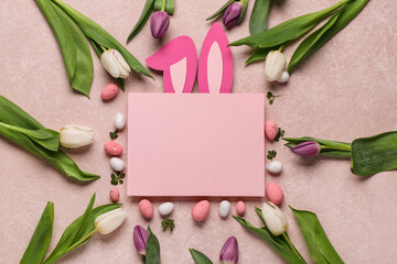 Blank card with Easter eggs, tulip flowers and paper rabbit ears on beige background