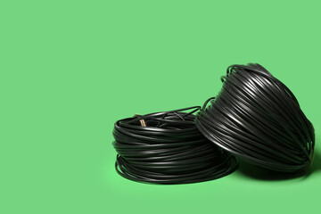Rolled cables on green background, closeup