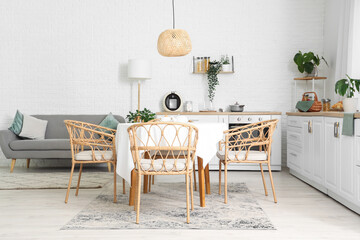 Interior of kitchen with white counters, grey sofa and dining table