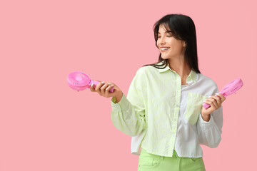 Young woman with mini fans on pink background