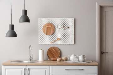 Interior of beautiful kitchen with white counters, sink and lamp