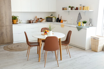 Interior of light kitchen with dining table and counters