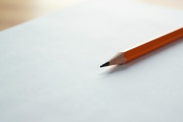 A single pencil rests on a blank white page, ready to write , writing, tool, craft