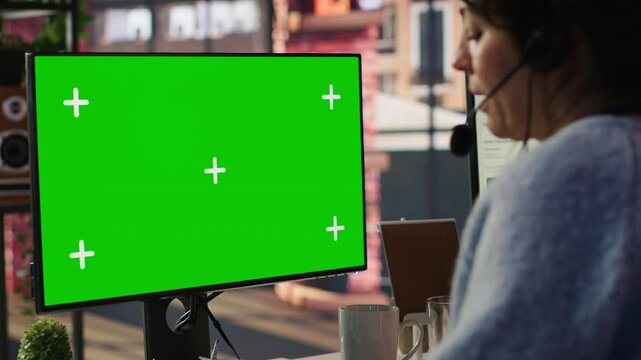 Call center agent providing live chat support using green screen PC, handling clients complaints. Employee using chroma key computer, dealing with unsatisfied customers, camera A close up