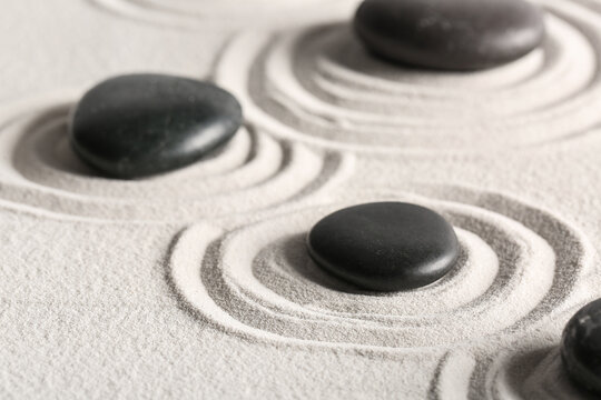 Black stones on sand with pattern in Japanese rock garden. Zen concept - Powered by Adobe