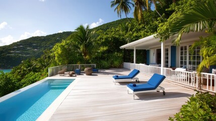 Fototapeta premium A chic seaside villa with a white deck, blue loungers, and surrounding greenery.
