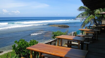 A tropical outdoor restaurant with wooden tables and a view of rolling waves.
