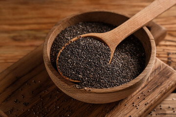Bowl with chia seeds on wooden background, closeup