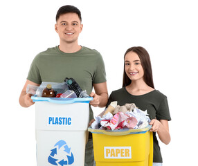 Young couple with sorted rubbish in garbage bins on white background. Global Recycling Day