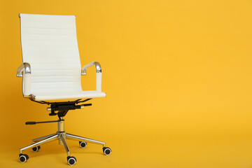 Modern office chair on yellow background. Space for text