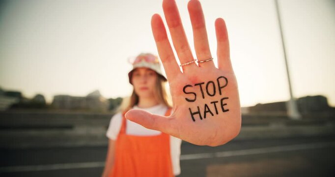Hands, woman and message for stop hate with war protest, justice news and speech of bullying announcement. Girl, portrait and warning sign for crime broadcast, human rights and propaganda outdoor