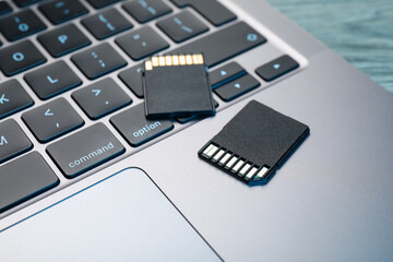 SD memory cards and laptop on table, closeup