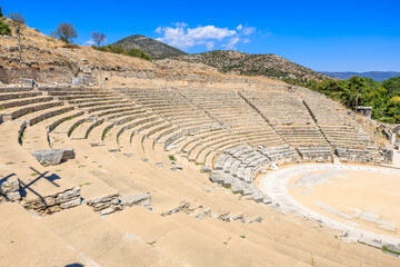 A large stone amphitheater with a stage and a few seats. Ruins of the ancient city of Philippi,...