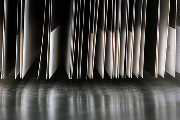 Pages of an open book reflecting on the surface of the desk