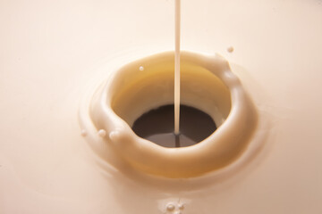 Dynamic shot of milk pouring into a creamy pool, forming a swirling vortex with ripples. Ideal for...