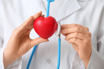 Female doctor with stethoscope and heart, closeup. World Health Day