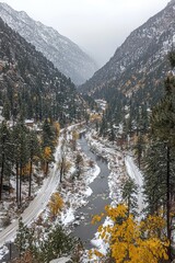 River flows through snow-dusted valley with autumn foliage, mountains, and cloudy sky in the background
