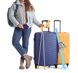 Female tourist with suitcases and skis on white background