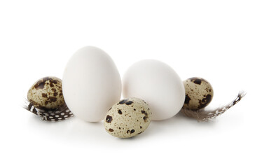 Obraz premium Chicken and quail eggs with feathers on white background. Easter celebration