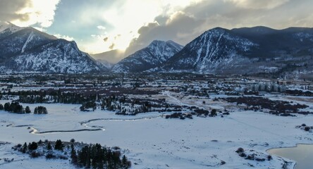 Aerial view of Frisco, Colorado, USA, in winter. Snow covers the ground and mountains. The sun...