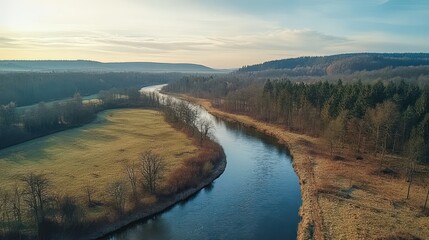 Aerial view River bends through autumnal forest, sunlit valley