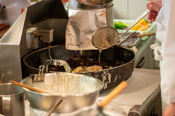 天ぷらを揚げる料理人