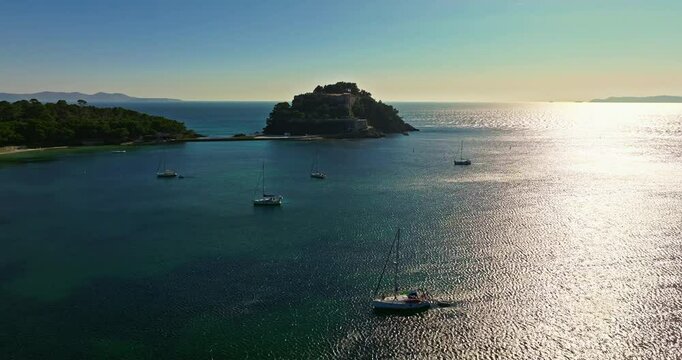 Aerial view of Fort Bregancon sunset aerial view from the mediterranean sea. A yacht is anchored near the fortress