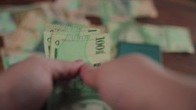 Man's hands counting Paraguayan currency bills