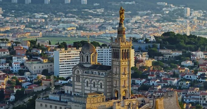 Aerial view of the Notre Dame de la Garde or Our Lady of the Guard church at sunset, southern France. The warm summer evening light illuminates the Marseille cityscape