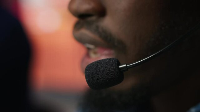 Extreme closeup of call center agent using audio headset microphone to provide guidance to customers. Customer center worker using headphones mic to walk clients through technical solutions, camera A