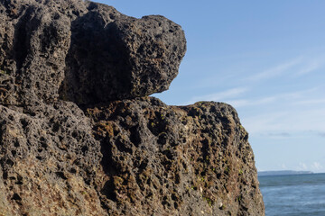 strong brown and textured rock at the beach 